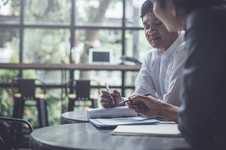 Discussing plan and idea to improvement strategy, businessmen brainstorming for strategy of business investment,businessmen review chart and document of investment informationの写真素材