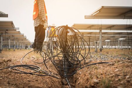 engineer and electrician installing solar tracking power plant; scope of work at solar power plant...