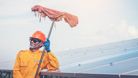 labor working on cleaning solar panel with water clean at solar power plantの写真素材
