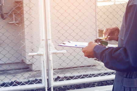 engineer or electrician working on checking and maintenance equipment at green energy solar power plant; checking status step up transformer high voltage at transformer yardの写真素材