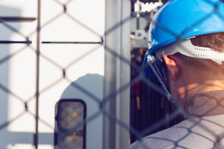 engineer or electrician working on checking and maintenance equipment at green energy solar power plant; checking status step up transformer high voltage at transformer yardの写真素材