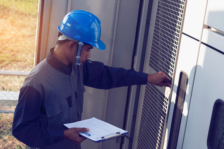 engineer or electrician working on checking and maintenance equipment at green energy solar power...