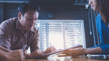 business partners signing contract to borrow money from investor to invest at own businessの写真素材