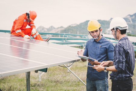 engineer in solar power plant working on installing solar panel ; operation of solar power plant by smart operatorの写真素材