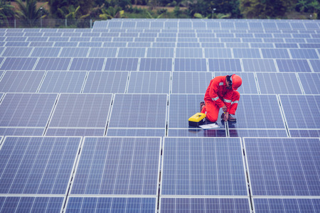 engineer in solar power plant working on installing solar panel ; operation of solar power plant by smart operatorの写真素材