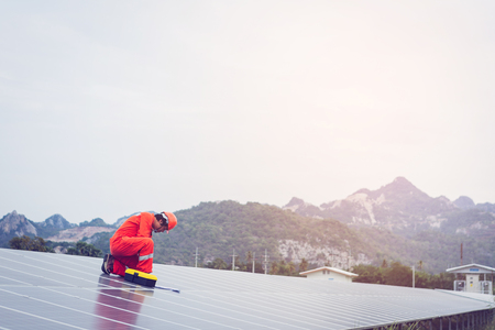 engineer in solar power plant working on installing solar panel ; operation of solar power plant by smart operatorの写真素材