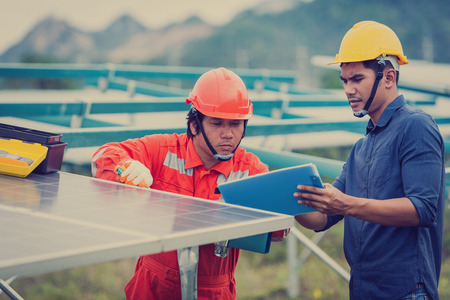 engineer in solar power plant working on installing solar panel ; operation of solar power plant by...