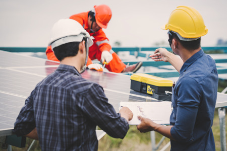 engineer in solar power plant working on installing solar panel ; operation of solar power plant by smart operator