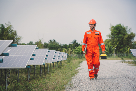 engineer in solar power plant working on installing solar panel ; operation of solar power plant by smart operatorの写真素材