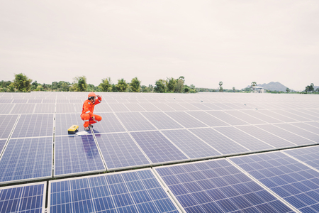 engineer in solar power plant working on installing solar panel ; operation of solar power plant by smart operatorの写真素材