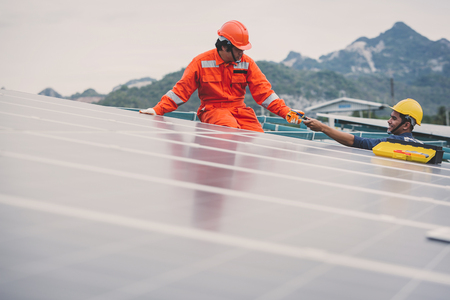 engineer in solar power plant working on installing solar panel ; operation of solar power plant by smart operatorの写真素材