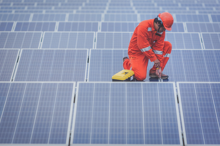 engineer in solar power plant working on installing solar panel ; operation of solar power plant by smart operatorの写真素材
