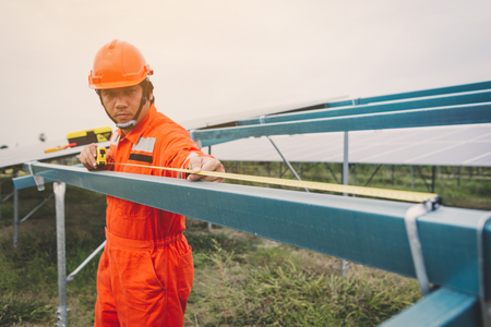 engineer in solar power plant working on installing solar panel ; operation of solar power plant by smart operatorの写真素材