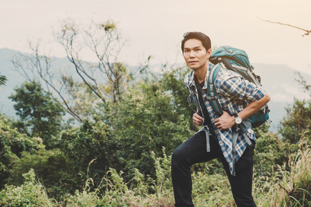 Hiking man traveling with backpack in mountainsの写真素材
