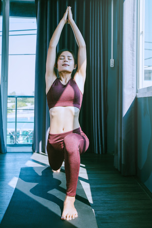 young woman practicing yoga in class; Beautiful girl feeling Calmness and relax in yoga classの写真素材