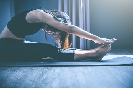 young woman practicing yoga in class; Beautiful girl feeling Calmness and relax in yoga classの写真素材