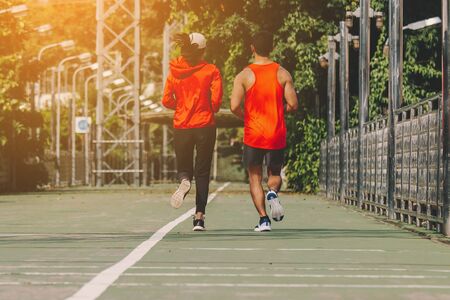 young couple runner running on running road in city park;sport, people, exercising and lifestyle conceptの写真素材