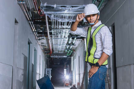 Project engineer, engineer working on blueprint architectural project at construction siteの写真素材