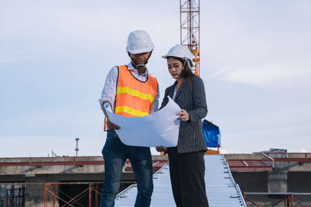 Project engineer, engineer working on blueprint architectural project at construction site