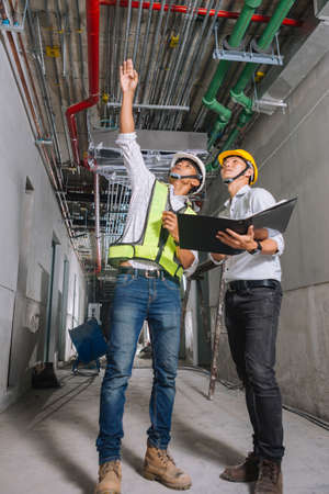 Project engineer, engineer working on blueprint architectural project at construction siteの写真素材