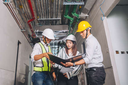 Project engineer, engineer working on blueprint architectural project at construction siteの写真素材