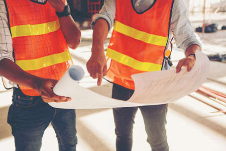 Project engineer, engineer working on blueprint architectural project at construction site