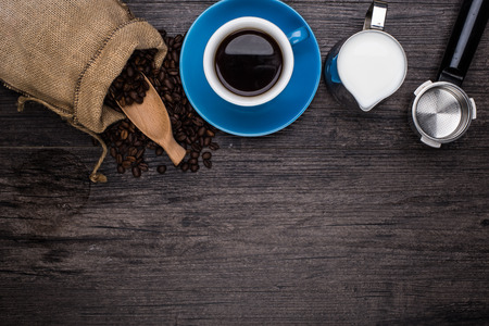cup of coffee with scattered coffee grains are on the wood backgroundの写真素材