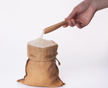 basmati rice in a wooden bowl isolated on white backgroundの写真素材
