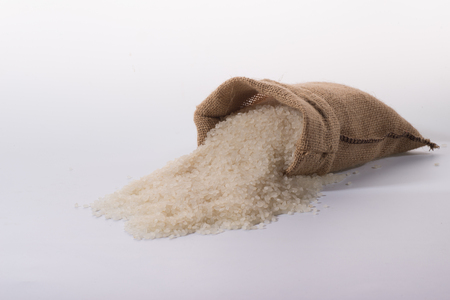 basmati rice in a wooden bowl isolated on white backgroundの写真素材