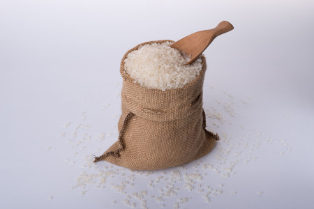basmati rice in a wooden bowl isolated on white backgroundの写真素材