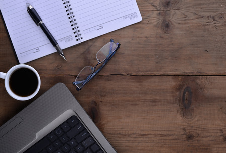 office table with notebook, computer keyboard, mouse, cup of coffee, tablet pc and smartphone. copy spaceのeditorial素材