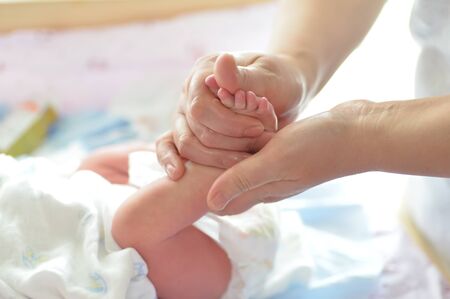 Mother massaging her child's foot, shallow focusの写真素材