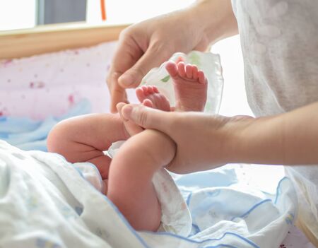 Mother massaging her child's foot, shallow focusの写真素材