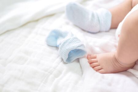 Close-up of mother hands holding tiny baby feetの写真素材
