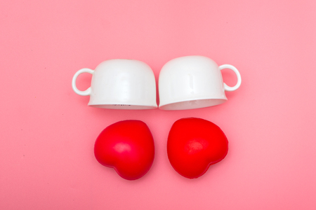 Happy cups with marshmalloHappy cup on heart-shaped pink pastel background, concept about love and relationships.の写真素材