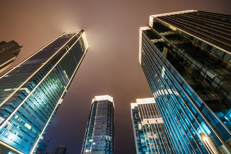 Looking up at the skyscrapers of the financial center at nightの写真素材