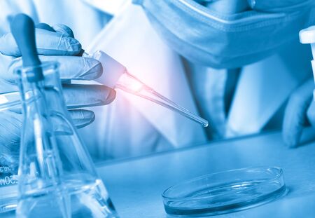 Laboratory beaker in analyst's hand in plastic gloveの写真素材