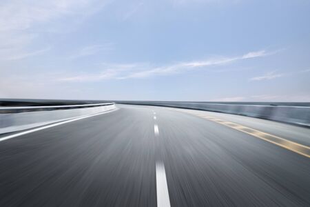 Motion-blurred highway in dusk cloudsの写真素材