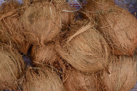 stack of ripped coconuts for sale at marketの写真素材
