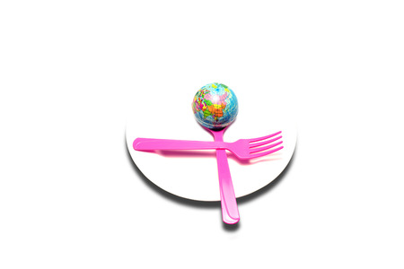 a globe in white dish with spoon and fork  on isolated backgroundの写真素材