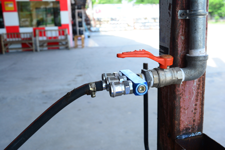 the pressure valve for mechanic job connect with iron tube  with rusty metal pole at car repair shopの写真素材
