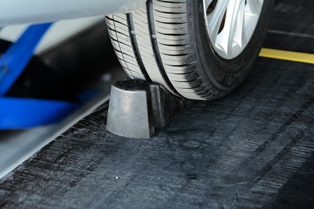 metal wheel with black tyre on alignment podium at car repair shopの写真素材