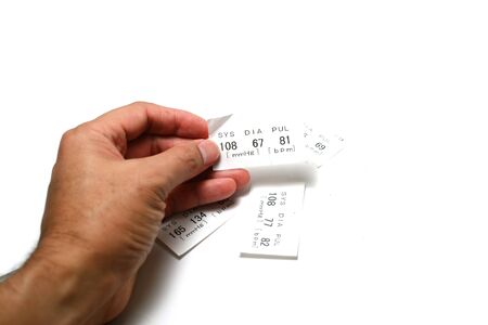 adult male hand holding a white paper data of systolic ,diastolic and pulse  after examination with...