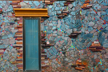 the colorful of old wall made from color stone cladding and a small window  at the local home in the northern of Thailandの写真素材