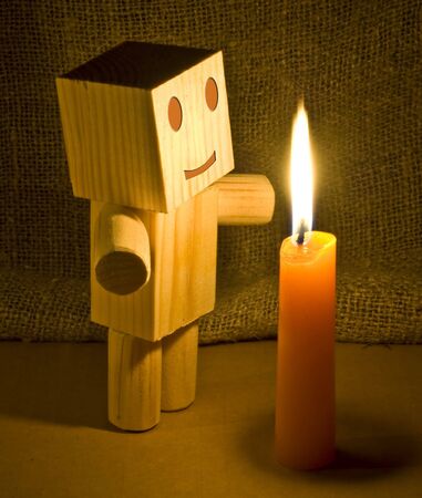 a wooden robot found out a conflagrant candleの写真素材