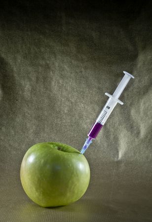 apple with a syringe on a dark backgroundの写真素材