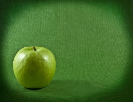 a ripe apple on a green backgroundの写真素材