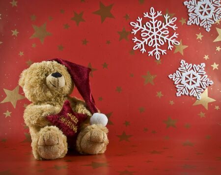 toy bear in a red cap with a red backgroundの写真素材