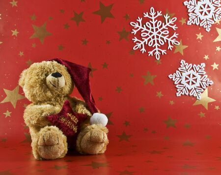 toy bear in a red cap with a red backgroundの写真素材