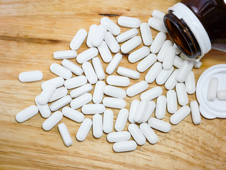 Calcium tablets on woodの写真素材